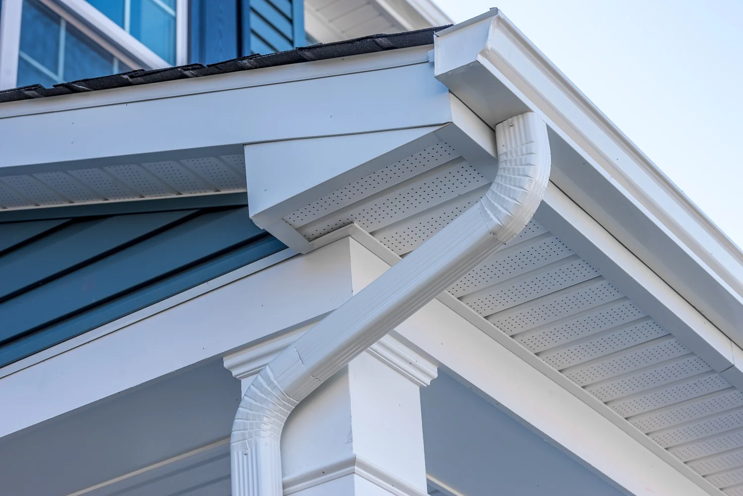 A side view of a house featuring a gutter, highlighting the siding and the overall exterior design.