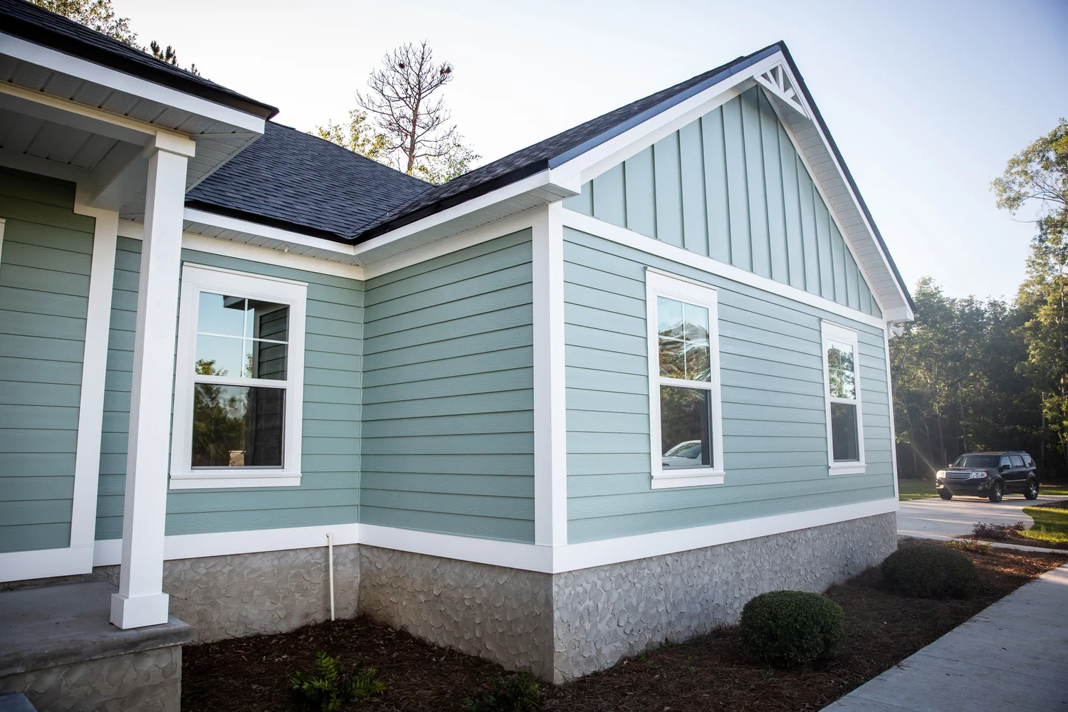 The exterior of a house with blue siding and white trim, highlighting potential for door and window replacement services.