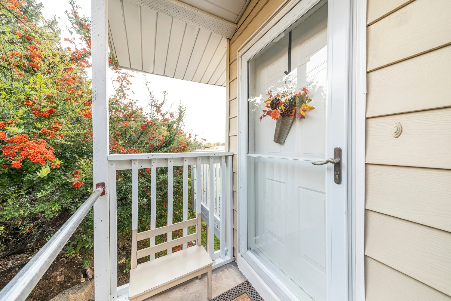 A porch displaying a door and railing, emphasizing siding installation.